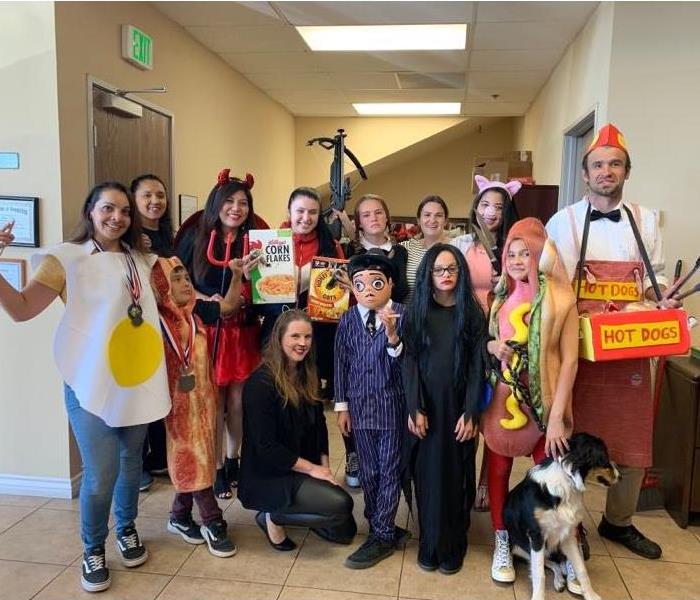 Team members dressed up for a group Halloween photo.